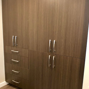 Idee per un armadio o armadio a muro unisex minimalista di medie dimensioni con ante lisce, ante con finitura invecchiata, pavimento in legno massello medio e pavimento marrone