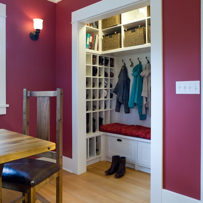 Inspiration for a mid-sized timeless gender-neutral light wood floor reach-in closet remodel in Seattle with recessed-panel cabinets and white cabinets