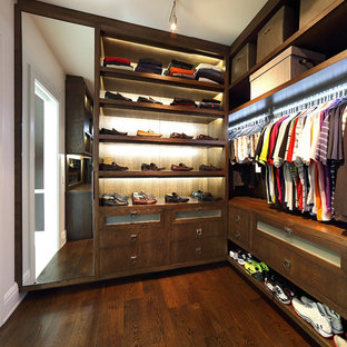 Immagine di una grande cabina armadio per uomo design con nessun'anta, ante in legno bruno e parquet scuro