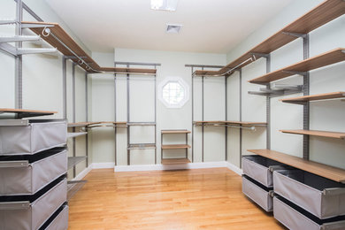 This is an example of an expansive modern gender neutral walk-in wardrobe in Providence with flat-panel cabinets, medium wood cabinets, medium hardwood flooring and brown floors.