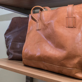 Immagine di un'ampia cabina armadio unisex moderna con ante lisce, ante in legno scuro, pavimento in legno massello medio e pavimento marrone