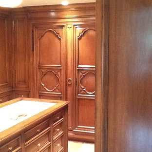 Foto de armario vestidor unisex, tradicional, grande, con armarios con paneles empotrados, puertas de armario de madera en tonos medios y suelo beige