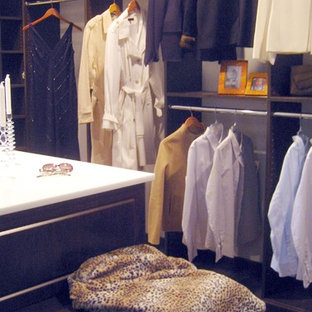 Ispirazione per un'ampia cabina armadio unisex classica con ante con bugna sagomata, ante in legno bruno, pavimento in legno massello medio e pavimento marrone
