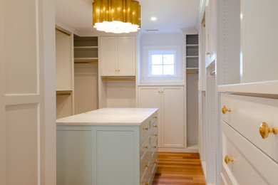 Inspiration for an expansive classic gender neutral walk-in wardrobe in Bridgeport with shaker cabinets, white cabinets, light hardwood flooring and beige floors.