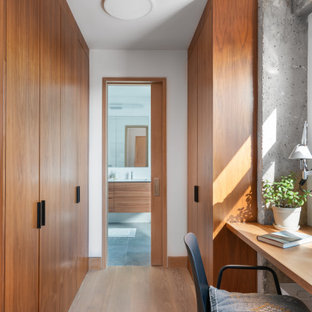 Trendy light wood floor and beige floor dressing room photo in New York with flat-panel cabinets and medium tone wood cabinets