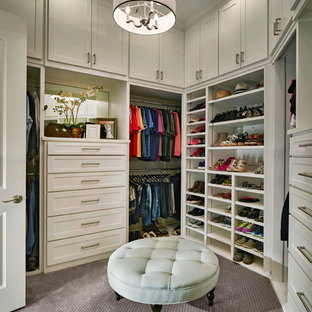 Inredning av ett klassiskt walk-in-closet för könsneutrala, med vita skåp och heltäckningsmatta