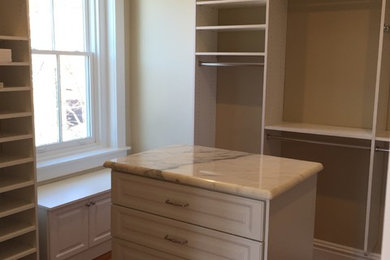 Inspiration for a large modern gender-neutral medium tone wood floor dressing room remodel in Richmond with recessed-panel cabinets and white cabinets