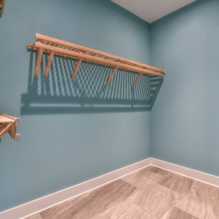 Immagine di una piccola cabina armadio unisex stile americano con pavimento in gres porcellanato e pavimento beige