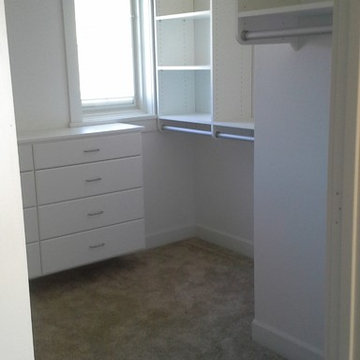Master closet in white with etched silver poles & drawers under window