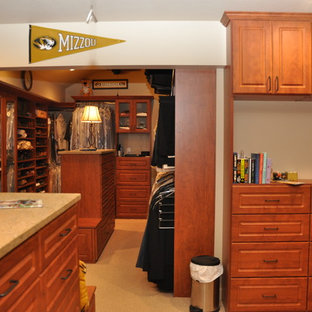 Immagine di un'ampia cabina armadio chic con ante con bugna sagomata, ante in legno scuro e moquette