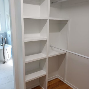 Idéer för mellanstora funkis walk-in-closets för könsneutrala, med öppna hyllor, vita skåp, mellanmörkt trägolv och brunt golv