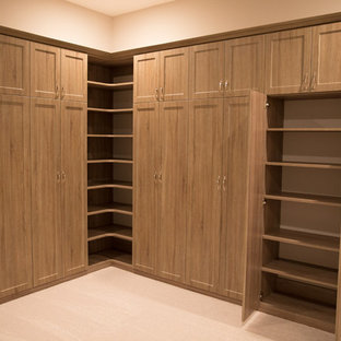Foto di un grande spazio per vestirsi per donna american style con moquette, ante in stile shaker, ante in legno chiaro e pavimento beige