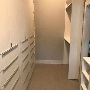 Imagen de armario vestidor unisex, clásico, de tamaño medio, con armarios con paneles lisos, puertas de armario blancas, suelo de baldosas de cerámica y suelo gris