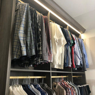 Großer Moderner Begehbarer Kleiderschrank mit flächenbündigen Schrankfronten, grauen Schränken, Teppichboden und blauem Boden in New York