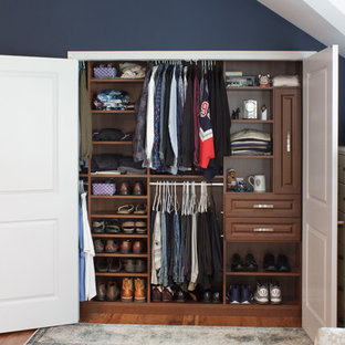 EIngebautes, Kleines Klassisches Ankleidezimmer mit profilierten Schrankfronten, dunklen Holzschränken und braunem Holzboden in New York