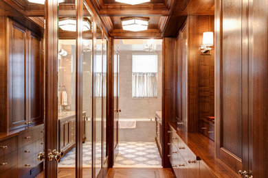 Inspiration for a mid-sized timeless men's medium tone wood floor dressing room remodel in New York with recessed-panel cabinets and medium tone wood cabinets