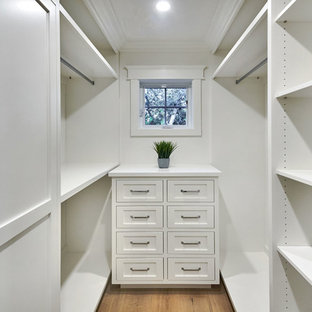 Lantlig inredning av ett litet walk-in-closet för könsneutrala, med skåp i shakerstil, vita skåp, ljust trägolv och grått golv