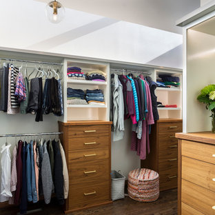 Geräumiger, Neutraler Retro Begehbarer Kleiderschrank mit flächenbündigen Schrankfronten, hellbraunen Holzschränken, dunklem Holzboden und braunem Boden in Portland