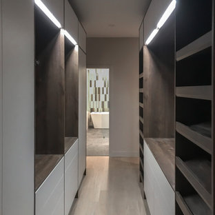 Foto de armario vestidor retro, de tamaño medio, con armarios con paneles lisos, puertas de armario de madera en tonos medios y suelo de madera clara