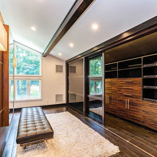 Inspiration pour un très grand dressing room vintage pour un homme avec un placard à porte plane, des portes de placard en bois brun, sol en stratifié et un sol marron.