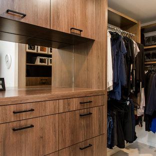 Ejemplo de armario vestidor unisex, vintage, de tamaño medio, con armarios con paneles lisos, puertas de armario de madera oscura y suelo de madera clara