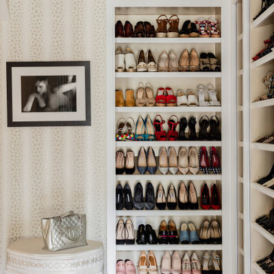 Example of a huge transitional gender-neutral dark wood floor and brown floor walk-in closet design in Boston with recessed-panel cabinets and white cabinets