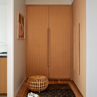 Foto de armario y vestidor unisex, escandinavo, con armarios con paneles lisos, puertas de armario de madera clara y suelo de madera clara