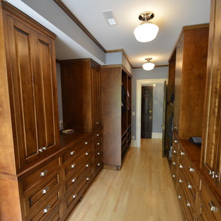 Foto de vestidor unisex, clásico, grande, con puertas de armario con efecto envejecido, suelo de madera clara y armarios con paneles empotrados