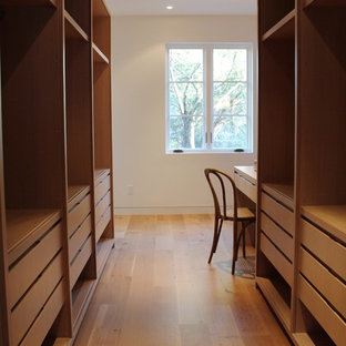 Foto di una cabina armadio unisex mediterranea di medie dimensioni con ante lisce, ante in legno chiaro e parquet chiaro