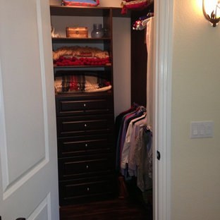 Foto de armario vestidor unisex, tradicional renovado, pequeño, con armarios con paneles empotrados, puertas de armario de madera en tonos medios y suelo de madera oscura
