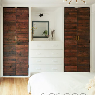 Imagen de vestidor unisex, escandinavo, grande, con armarios con paneles lisos, puertas de armario de madera en tonos medios y suelo de madera clara