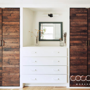 Imagen de vestidor unisex, escandinavo, de tamaño medio, con armarios con paneles lisos, puertas de armario de madera en tonos medios y suelo de madera clara