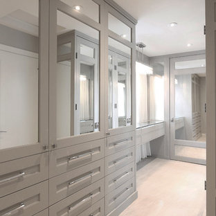 Ejemplo de armario vestidor unisex, actual, grande, con armarios con rebordes decorativos, puertas de armario grises, suelo de baldosas de porcelana y suelo beige