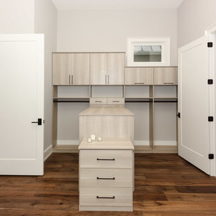 Esempio di una cabina armadio unisex country di medie dimensioni con ante lisce, ante in legno chiaro e pavimento in legno massello medio