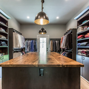 Diseño de vestidor de hombre, campestre, de tamaño medio, con armarios con paneles lisos, puertas de armario de madera en tonos medios, suelo de madera clara y suelo beige