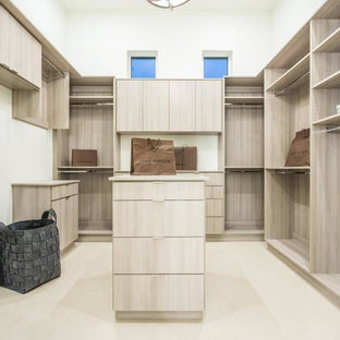 Imagen de armario vestidor unisex, moderno, extra grande, con armarios con paneles lisos, puertas de armario de madera clara, suelo de baldosas de porcelana y suelo beige