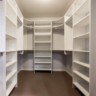 Esempio di una grande cabina armadio industriale con ante bianche e moquette