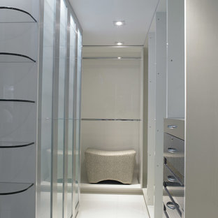 Modelo de armario vestidor de hombre, moderno, de tamaño medio, con armarios con paneles lisos, puertas de armario grises, suelo de baldosas de porcelana y suelo beige