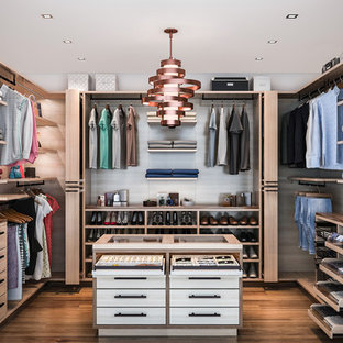 Bild på ett mellanstort funkis walk-in-closet för könsneutrala, med släta luckor, skåp i mellenmörkt trä och mellanmörkt trägolv