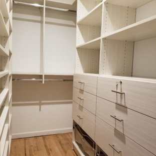 Exempel på ett stort modernt walk-in-closet för könsneutrala, med släta luckor, skåp i ljust trä, ljust trägolv och beiget golv