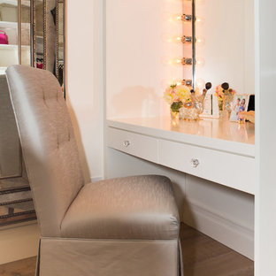 Immagine di una grande cabina armadio per donna mediterranea con ante in stile shaker, ante bianche e parquet chiaro