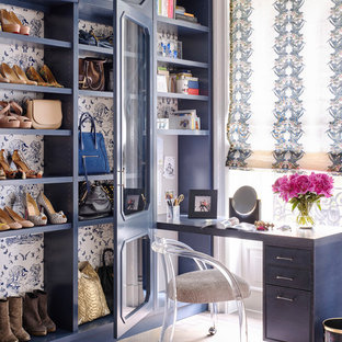 Diseño de vestidor tradicional renovado con puertas de armario azules, suelo de madera en tonos medios y suelo marrón