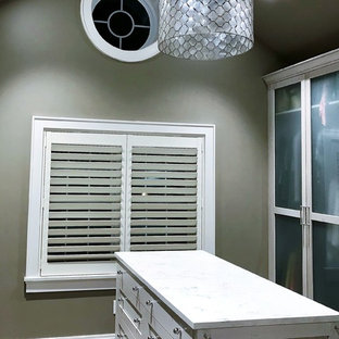 Ispirazione per una cabina armadio unisex american style di medie dimensioni con ante di vetro, ante con finitura invecchiata, pavimento in gres porcellanato e pavimento grigio