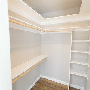 Modelo de armario vestidor unisex, clásico renovado, de tamaño medio, con puertas de armario blancas, suelo laminado y suelo marrón