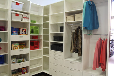 Walk-in closet - mid-sized contemporary gender-neutral walk-in closet idea in Sacramento with white cabinets