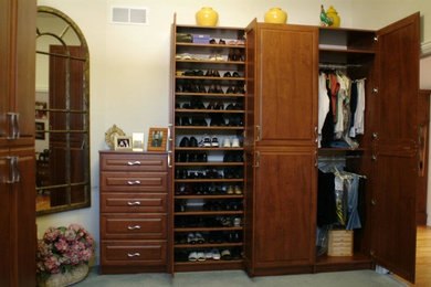 Ejemplo de armario y vestidor unisex pequeño con puertas de armario de madera oscura