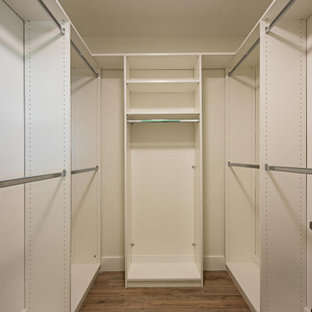 Cette photo montre un petit dressing bord de mer neutre avec un placard à porte shaker, des portes de placard blanches, un sol en carrelage de céramique et un sol marron.