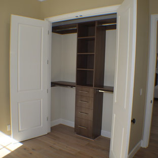 Diseño de armario unisex, clásico, pequeño, con armarios estilo shaker, puertas de armario de madera en tonos medios, suelo de madera clara y suelo marrón