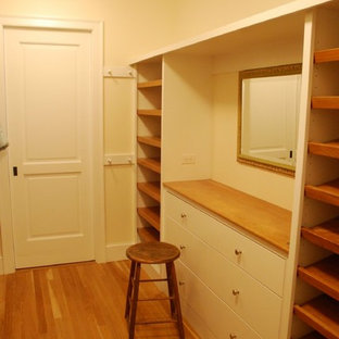 Esempio di una grande cabina armadio tradizionale con ante lisce, ante bianche e parquet chiaro