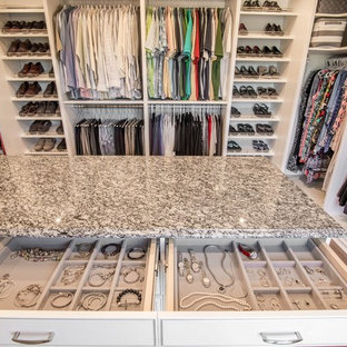 Ejemplo de armario vestidor unisex, clásico, grande, con armarios abiertos, puertas de armario blancas, suelo de madera oscura y suelo marrón